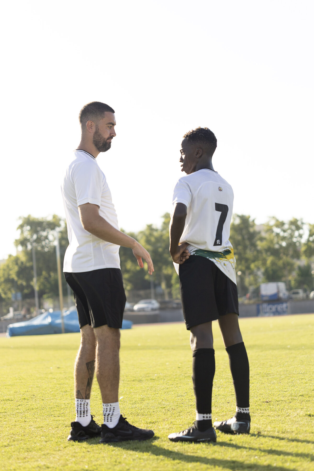 Coach talking a player through the game plan pitch-side